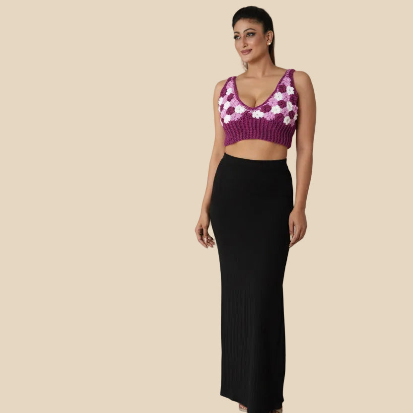 Woman wearing a black skirt and purple floral top on a white background