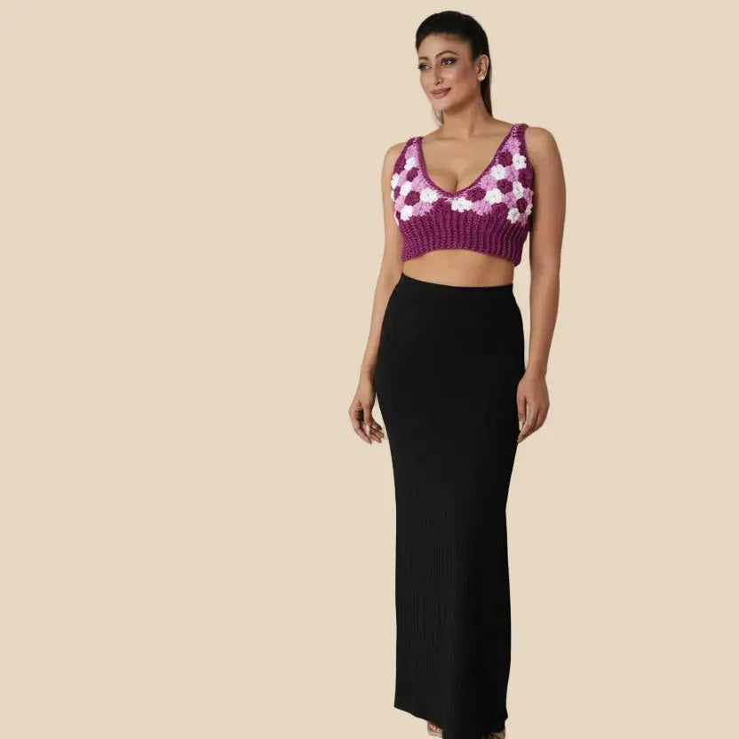 Woman wearing a black skirt and purple floral top on a white background