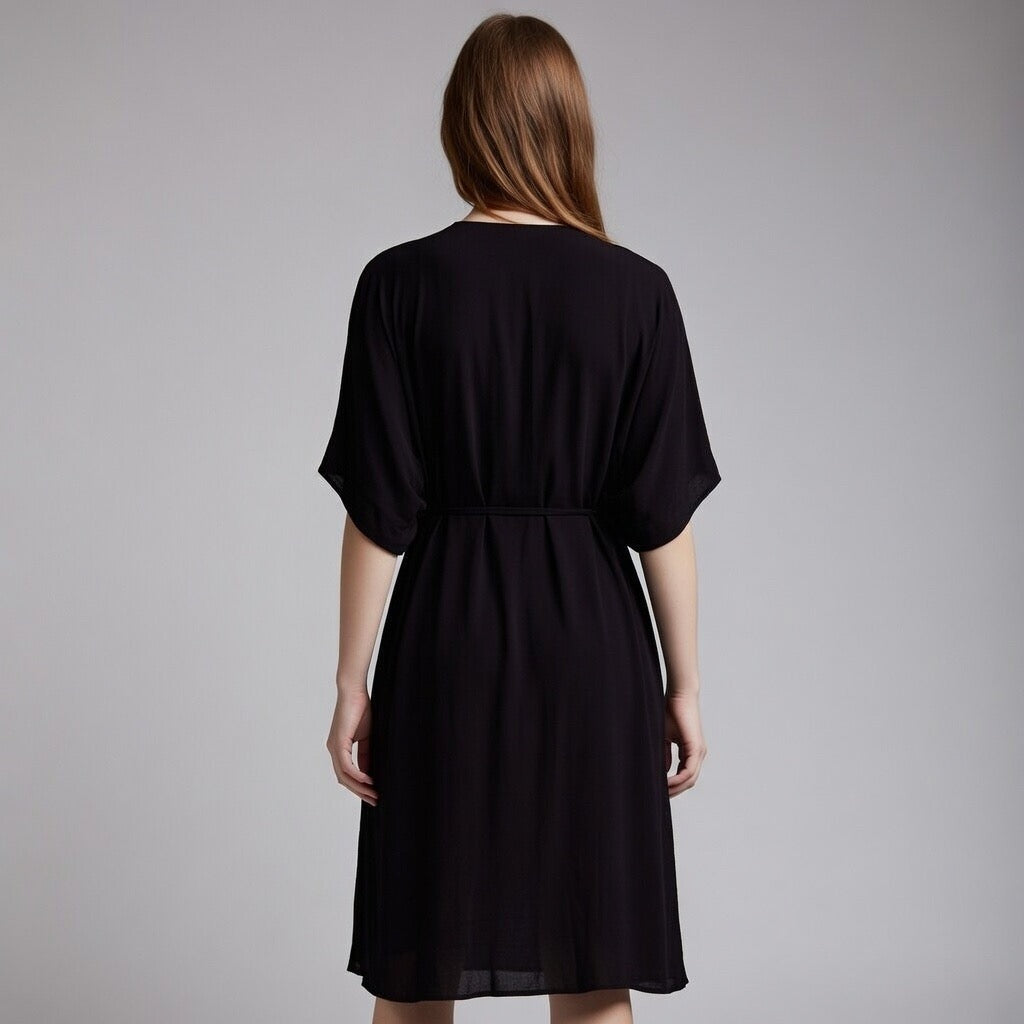 Woman wearing a black dress against a grey background