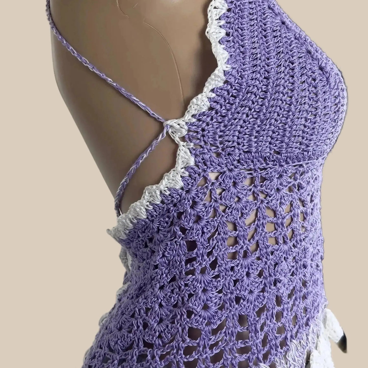 Purple crochet top on a mannequin against a white door background