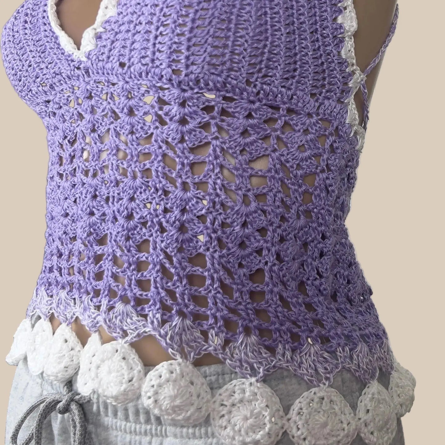 Purple crochet top on a mannequin with a white background