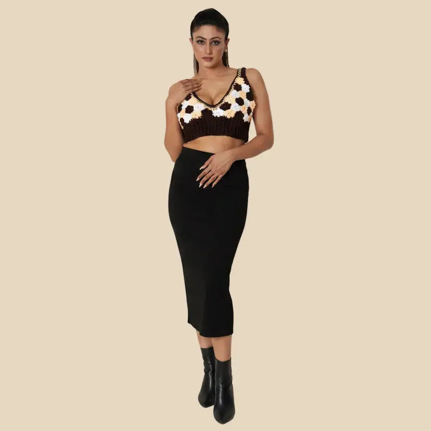 Woman wearing a black and brown patterned top with a black skirt on a white background