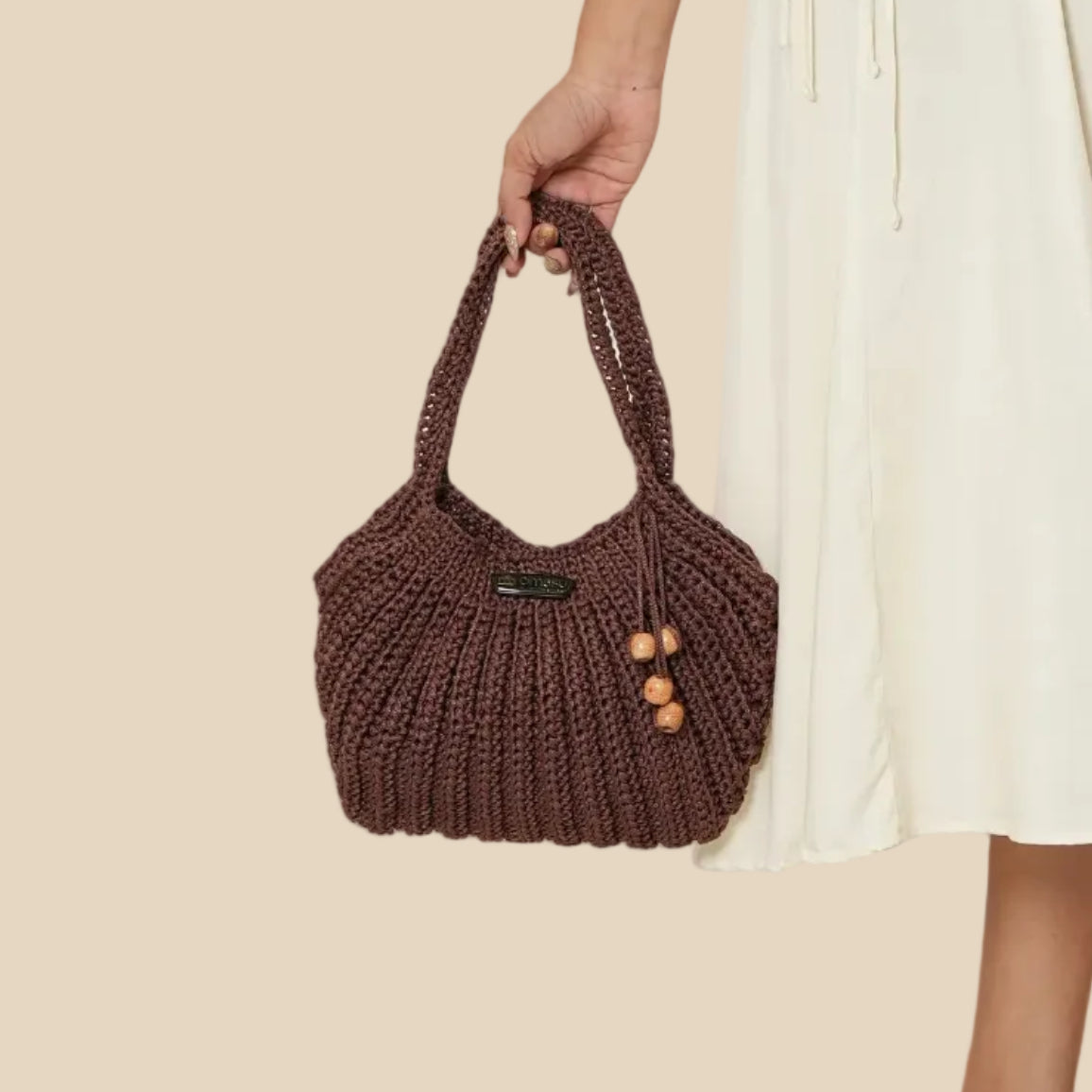 Woman in a white dress holding a brown handbag on a beige background