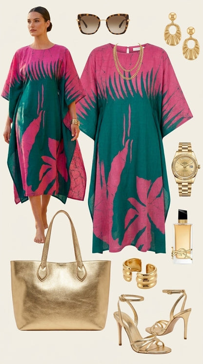 Woman wearing a pink and green handmade batik dress with fashion accessories including sunglasses, earrings, a handbag, shoes, and a watch.