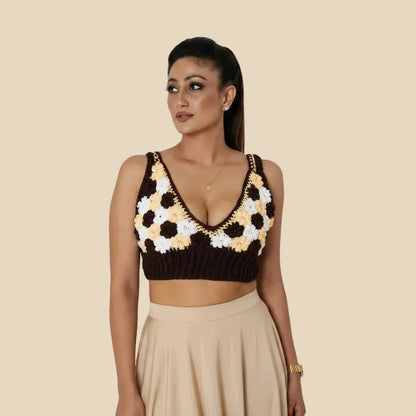 Woman wearing a black and white floral crochet top on a beige background