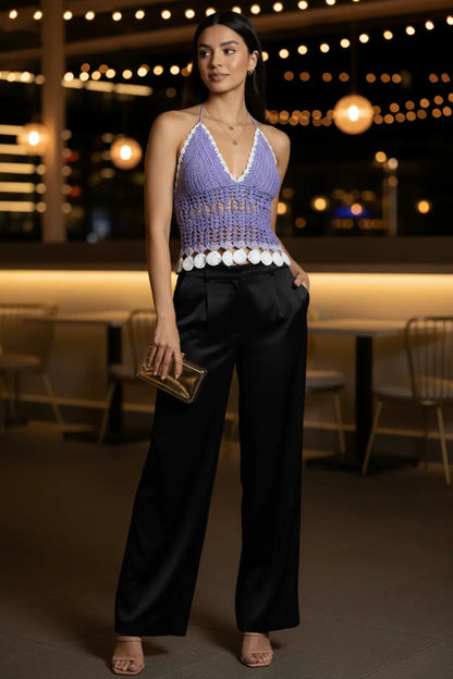A woman wearing a lavender crochet halter crop top with white trim and white scalloped coin details along the hem, standing in front of a white paneled door-Veyaro-UK