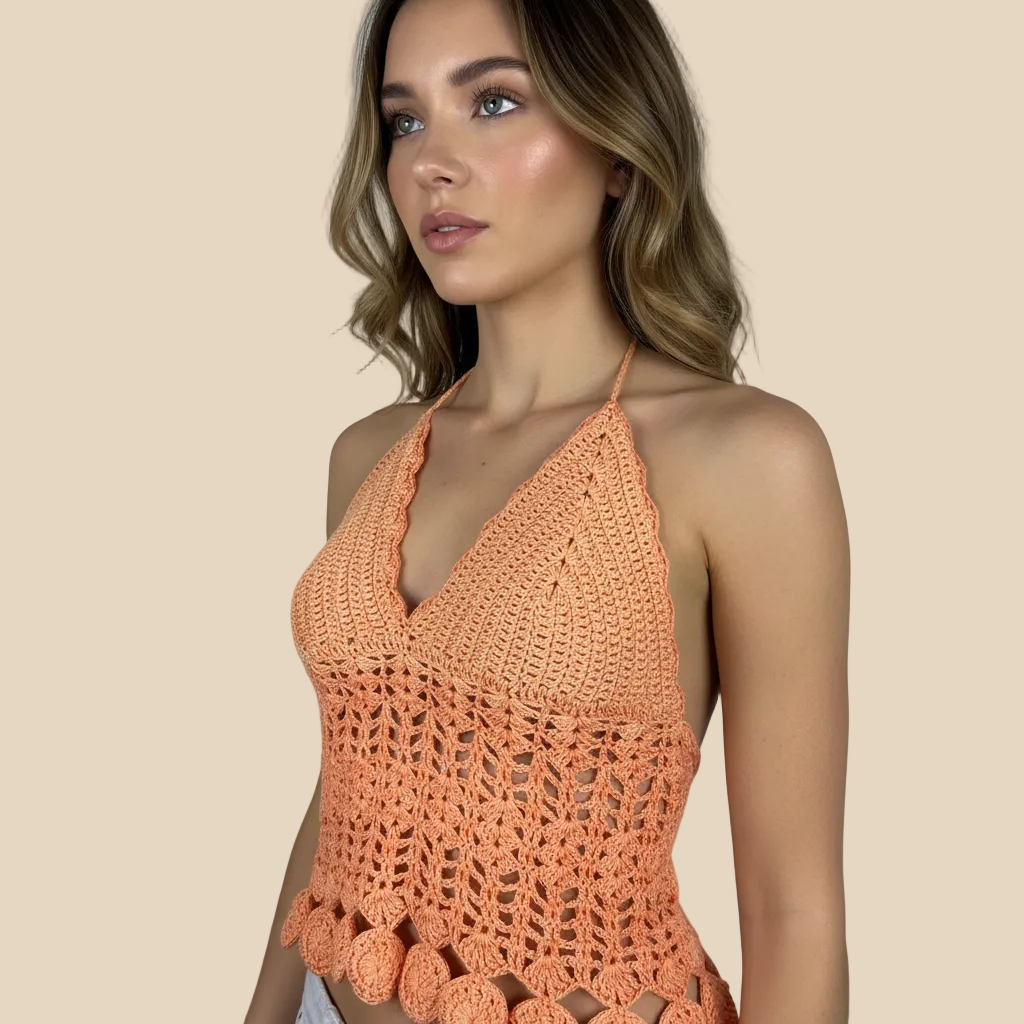Woman wearing a crochet orange top against a neutral background