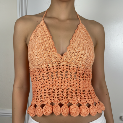 Orange handmade crochet top with pom-pom details on a neutral background -Veyaro