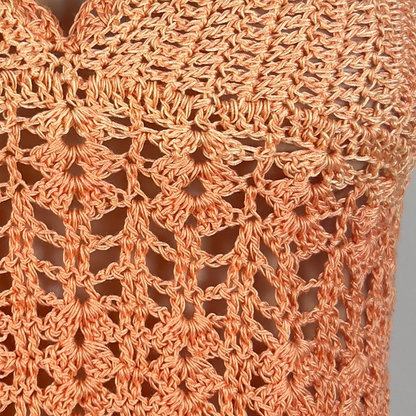 Close-up of a handcrafted crocheted orange fabric with intricate pattern