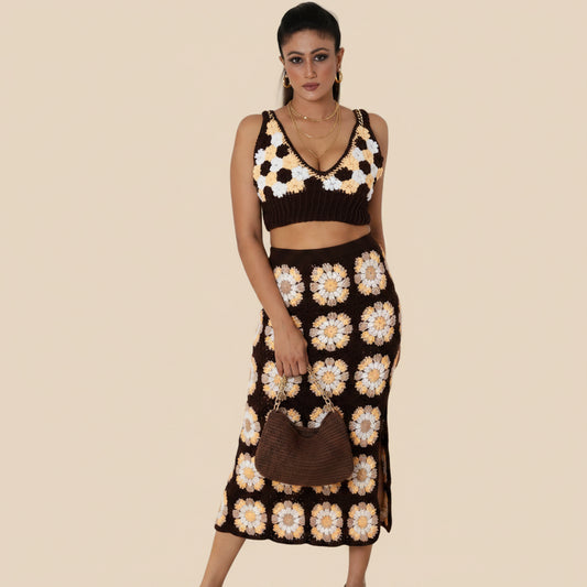 Woman wearing a crochet skirt with a floral top in a light beige background