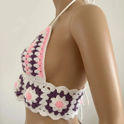 Mannequin wearing a colorful crochet bikini top on a plain background